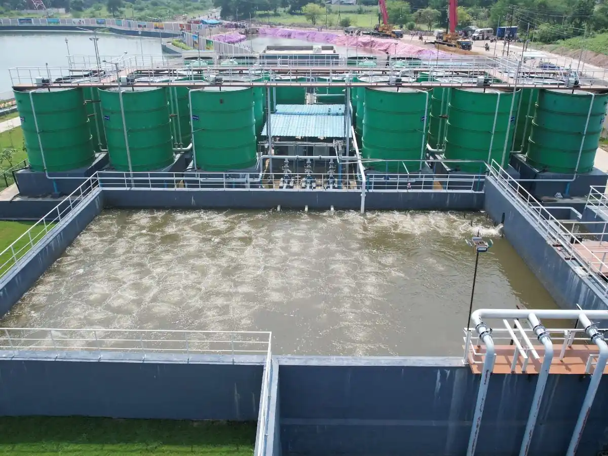 Aerial view of the SBS Water sewage treatment plant at Dahod, Gujarat, with green reactor tanks and an aerated treated-water tank