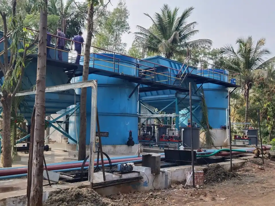 SBS Water operators on the walkway above the blue reactor and settler tanks at Satish Sugars
